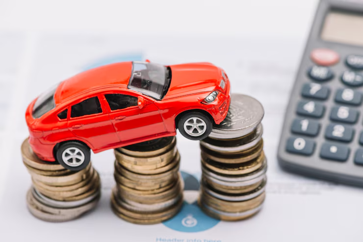 "Red toy car placed on stacks of coins next to a calculator, symbolizing car expenses, auto financing, or vehicle cost calculation."